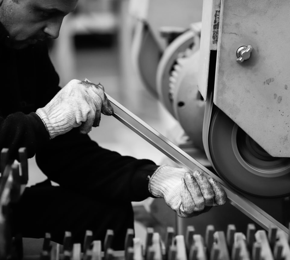 Man working with machinery in a factory setting, showcasing industrial production.