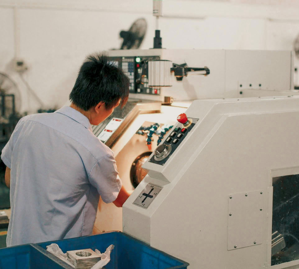 Worker focusing on operating industrial machinery in a factory setting.
