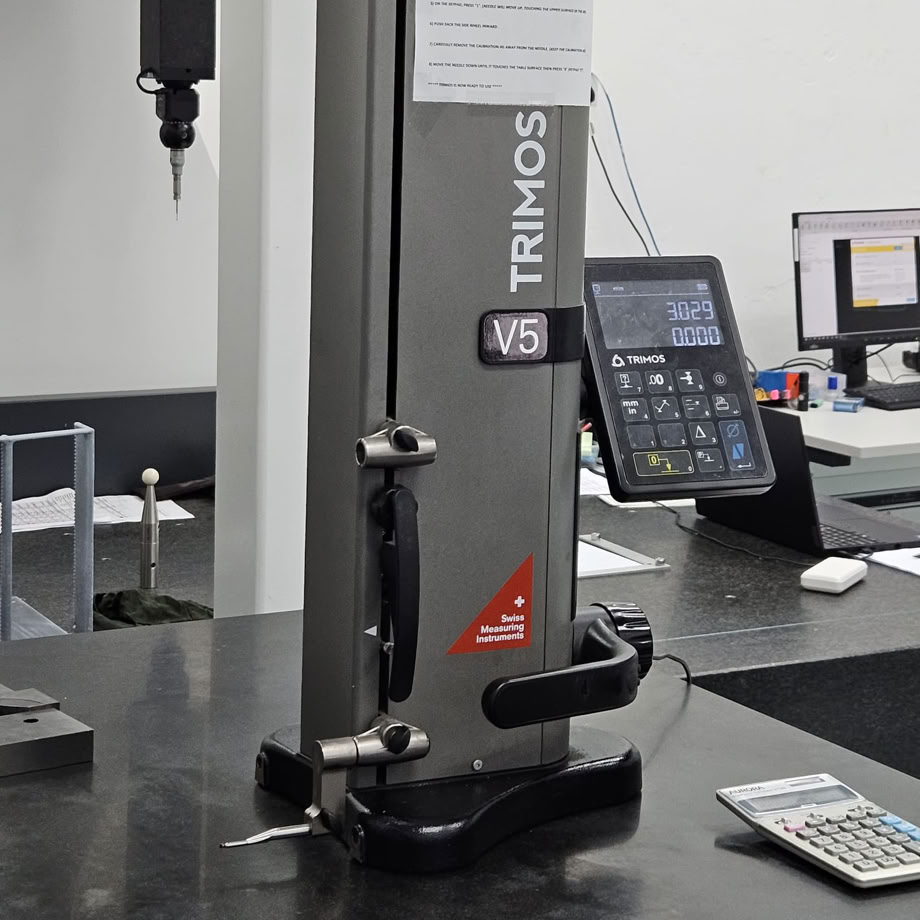 Close-up of an industrial CNC lathe in a bustling machine shop setting, focused on precision metalwork.